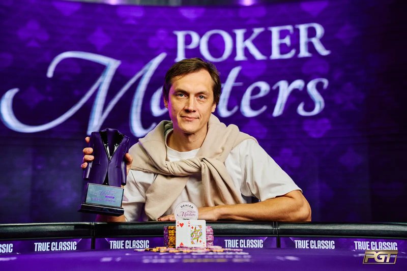 Vitalijs Zavorotnijs at the Poker Masters winner's table, smiling and holding the purple jacket trophy
